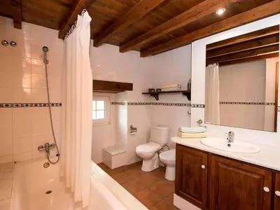 a bathroom with a tub and a toilet and a sink at Holiday Home Can Trullas by Interhome in Viladecaballs