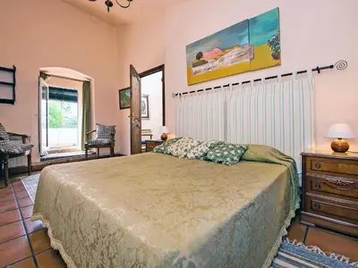 a bedroom with a bed and a dresser and a window at Holiday Home Can Trullas by Interhome in Viladecaballs