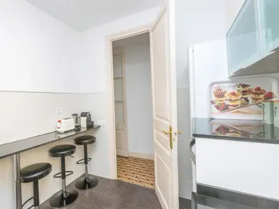 a small kitchen with stools in front of a counter at Apartment Eix-Dret-Roger de LLuria-Valencia by Interhome in Barcelona