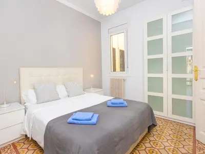 a white bedroom with a large bed with blue towels on it at Apartment Eix-Dret-Roger de LLuria-Valencia by Interhome in Barcelona
