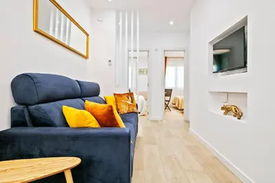 a blue couch with yellow pillows in a living room at Boutique Plaza Catalonia Suites Cornellá in Cornellà de Llobregat