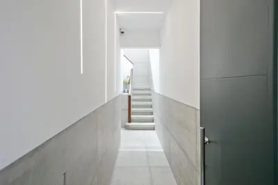 a hallway of a house with white walls and a door at Boutique Plaza Catalonia Suites Cornellá in Cornellà de Llobregat