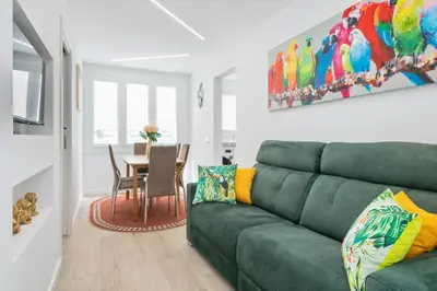 a living room with a green couch and a table at Boutique Plaza Catalonia Suites Cornellá in Cornellà de Llobregat