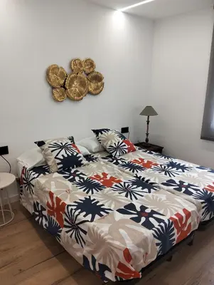 a bedroom with a bed with a colorful comforter at Vidanova 2 in Vilanova i la Geltrú