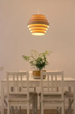 a dining room table with two chairs and a potted plant at Barcelona a 20 minutos en piso reformado y soleado in Gavà