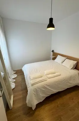 a bedroom with a white bed with two towels on it at Barcelona a 20 minutos en piso reformado y soleado in Gavà