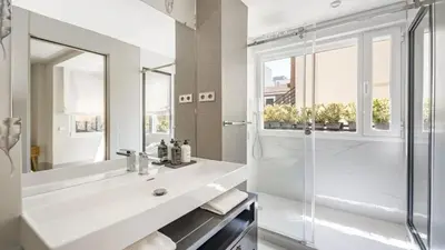 a white bathroom with a shower and a sink at Precioso Apartamento en Barcelona in Terrassa