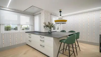 a kitchen with a island with green chairs at Precioso Apartamento en Barcelona in Terrassa