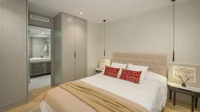 a bedroom with a large bed with two red pillows at Precioso Apartamento en Barcelona in Terrassa