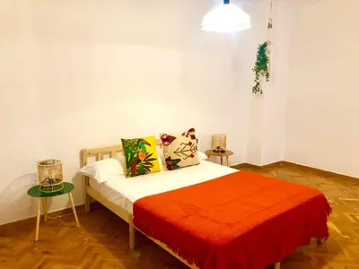 a bedroom with a bed with a red blanket at Tucan tropical in Sabadell