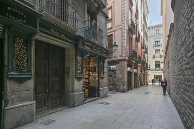 an empty street in a city with buildings at Alcam Sombrerers in Barcelona
