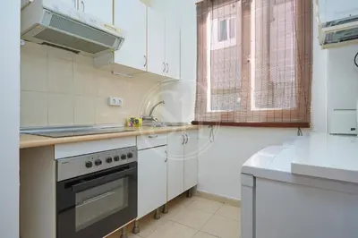 a white kitchen with a stove and a sink at Estudio en Gracia 2 in Barcelona