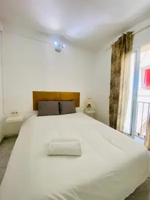 a large white bed in a room with a window at 022 Center Barca 1,1 in Barcelona