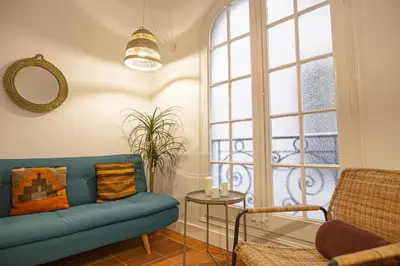 a living room with a blue couch and a window at Maravilloso apartamento en Poble Sec in Barcelona