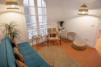 a living room with a blue couch and chairs at Maravilloso apartamento en Poble Sec in Barcelona