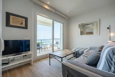a living room with a couch and a television at Sitges frente al mar in Sitges