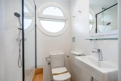 a white bathroom with a toilet and a sink at Sitges frente al mar in Sitges
