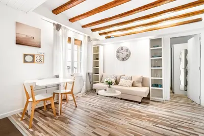 a living room with a couch and a table at Charming Beachside Apartment in Barceloneta in Barcelona