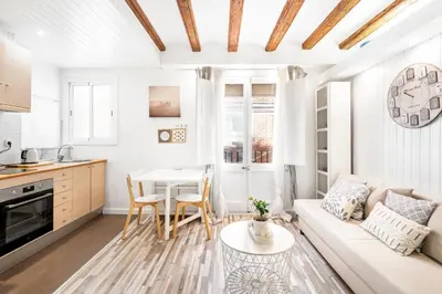 a living room with a couch and a table at Charming Beachside Apartment in Barceloneta in Barcelona