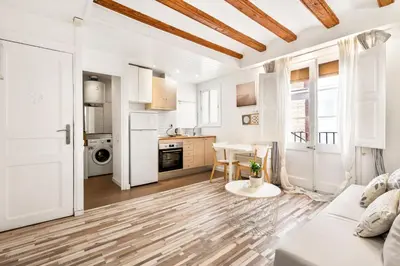 a white living room with a white couch and a table at Charming Beachside Apartment in Barceloneta in Barcelona