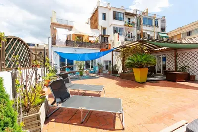 a patio with two chairs and a hammock at Apartamento con Terraza en Poble Sec in Barcelona