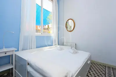 a white bathroom with a tub and a window at Apartamento con Terraza en Poble Sec in Barcelona