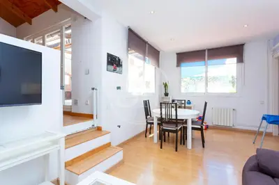a dining room and living room with a table and chairs at Apartamento con Terraza en Poble Sec in Barcelona