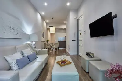 a living room with a white couch and a flat screen tv at BBarcelona Rogent Flats in Barcelona
