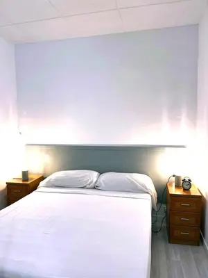 a bedroom with a white bed and two night stands at Apartamento 1 habitación cerca Sants-Estación in Barcelona