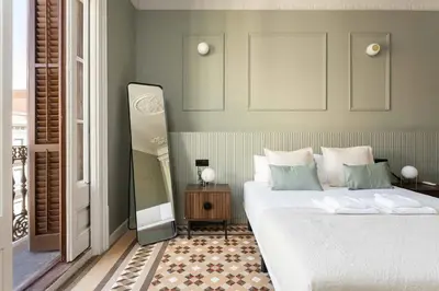 a bedroom with a large white bed and a mirror at Spacious Stylish 4-bedroom Modernist Apartment in Barcelona