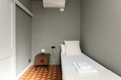 a small room with a bed and a night stand at Spacious Stylish 4-bedroom Modernist Apartment in Barcelona