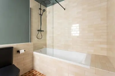 a bathroom with a tub and a glass shower at Spacious Stylish 4-bedroom Modernist Apartment in Barcelona