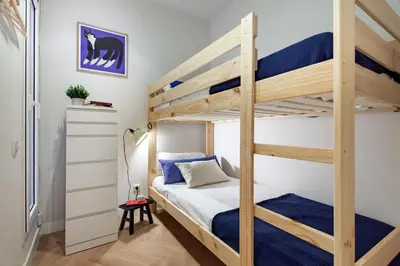 a bedroom with a bunk bed with blue sheets at Click&Flat Gaudi Dream II in Barcelona