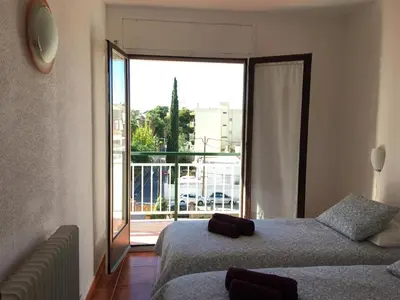 a bedroom with two beds and a large window at Apartamento La Mediterránea a 100 metros de la playa - Vilanova i la Geltrú - ES-332-1 in Vilanova i la Geltrú