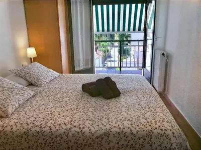 a bed with two brown towels on it with a window at Apartamento La Mediterránea a 100 metros de la playa - Vilanova i la Geltrú - ES-332-1 in Vilanova i la Geltrú