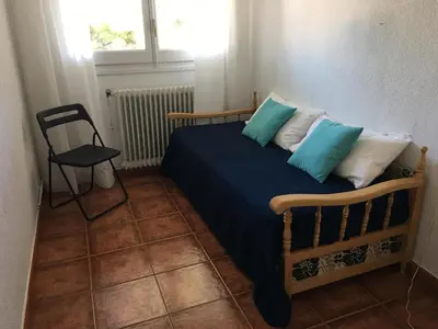 a bedroom with a bed with blue and white pillows at Apartamento La Mediterránea a 100 metros de la playa - Vilanova i la Geltrú - ES-332-1 in Vilanova i la Geltrú