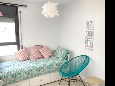 a room with a bench with pillows and a chair at Casa familiar luminosa con piscina, cerca de la playa y parques, ideal para 6 personas en Cubelles - ES-332-5 in Cubelles