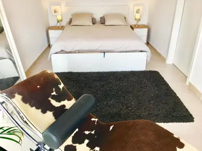 a bedroom with a bed and a cow rug at Casa familiar luminosa con piscina, cerca de la playa y parques, ideal para 6 personas en Cubelles - ES-332-5 in Cubelles