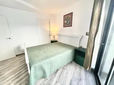 a bedroom with a green bed and a window at Apartamento Confortable con Parking Privado en el Centro de Vilanova i la Geltrú - ES-332-8 in Vilanova i la Geltrú