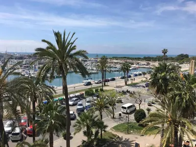 a parking lot with palm trees and a marina at Ático Familiar Renovado Frente al Mar con Terraza y Vistas Panorámicas en Vilanova i la Geltrú - ES-332-2 in Vilanova i la Geltrú