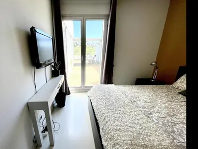 a bedroom with a bed and a tv and a window at Casa espaciosa con piscina, aire acondicionado y jardín cerca de la playa de Vilanova - ES-332-9 in Sant Pere de Ribes