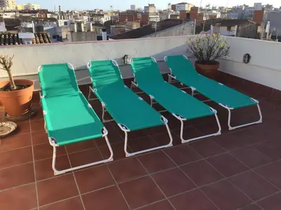 a group of green lounge chairs on a roof at Ático Increíble con Terraza Privada en el Centro de Vilanova i la Geltrú - ES-332-7 in Vilanova i la Geltrú