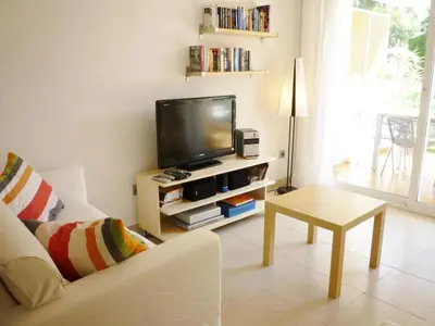 a living room with a tv and a couch and a table at Apartamento Annie a 100 metros de la playa en Vilanova i la Geltrú, completamente equipado. - ES-332-3 in Vilanova i la Geltrú
