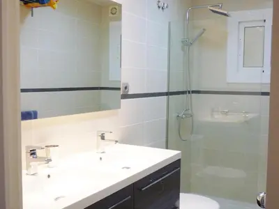 a bathroom with two sinks and a glass shower at Apartamento Annie a 100 metros de la playa en Vilanova i la Geltrú, completamente equipado. - ES-332-3 in Vilanova i la Geltrú