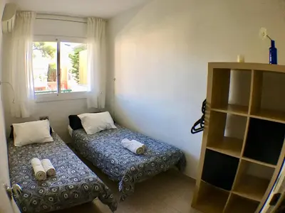 a bedroom with two beds and a book shelf at Apartamento Annie a 100 metros de la playa en Vilanova i la Geltrú, completamente equipado. - ES-332-3 in Vilanova i la Geltrú