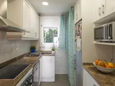 a kitchen with white cabinets and a bowl of fruit on the counter at Apartamento cómodo frente al mar con acceso directo a la playa - ES-332-6 in Vilanova i la Geltrú