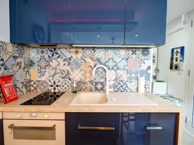 a kitchen with a sink and a tile wall at Balcis Apartment by Hello Homes Sitges in Sitges