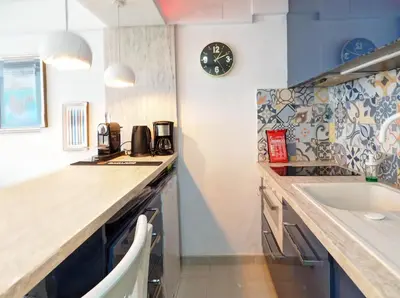 a kitchen with a sink and a clock on the wall at Balcis Apartment by Hello Homes Sitges in Sitges
