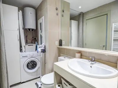 a bathroom with a sink and a washing machine at Balcis Apartment by Hello Homes Sitges in Sitges