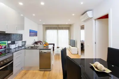 a kitchen with black counter tops and a living room at Key San Pau House Terrace - Barcelona in Barcelona